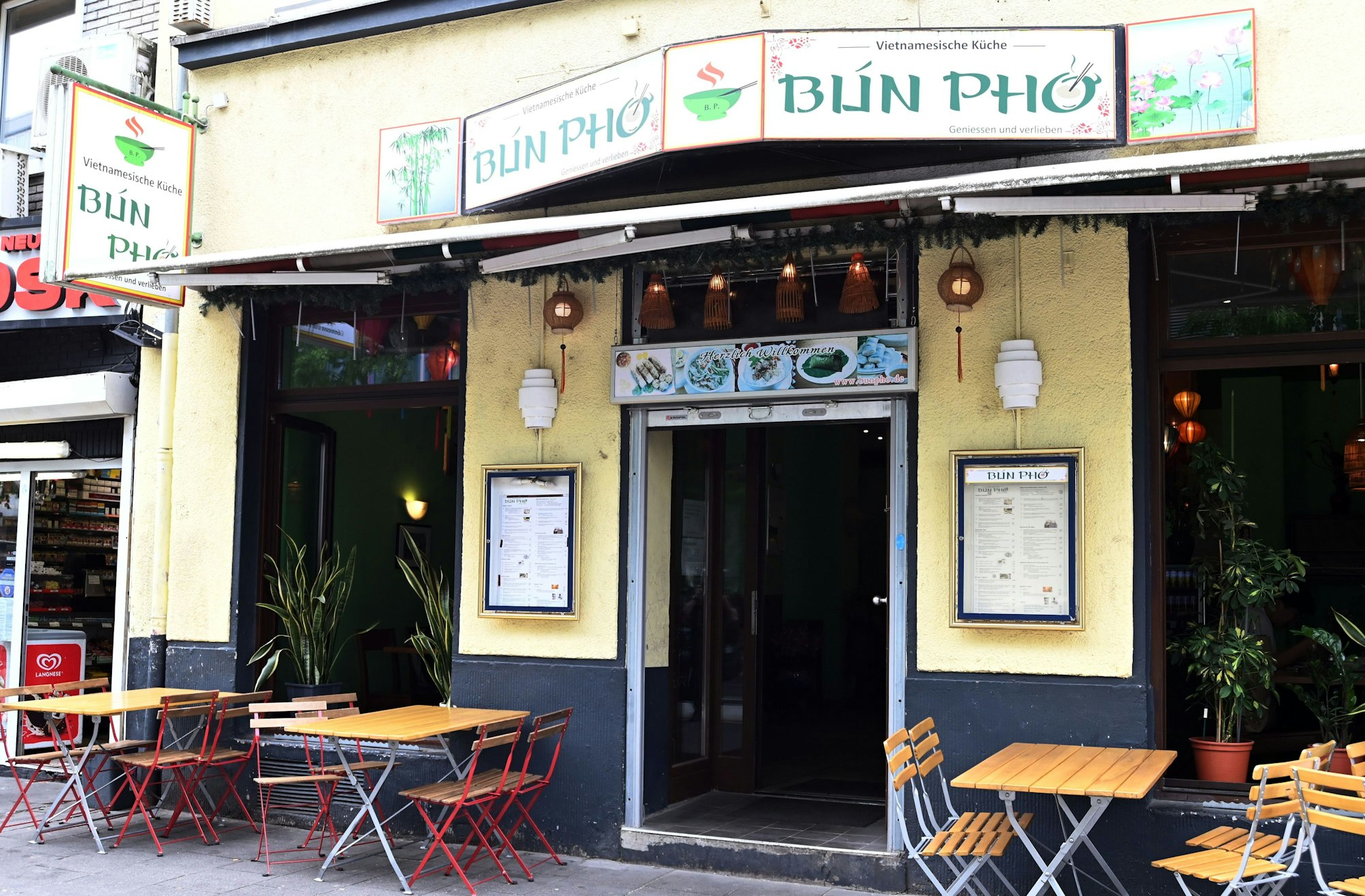 Die Fassade des Lokals ist mit einigen Außentischen zu sehen.
