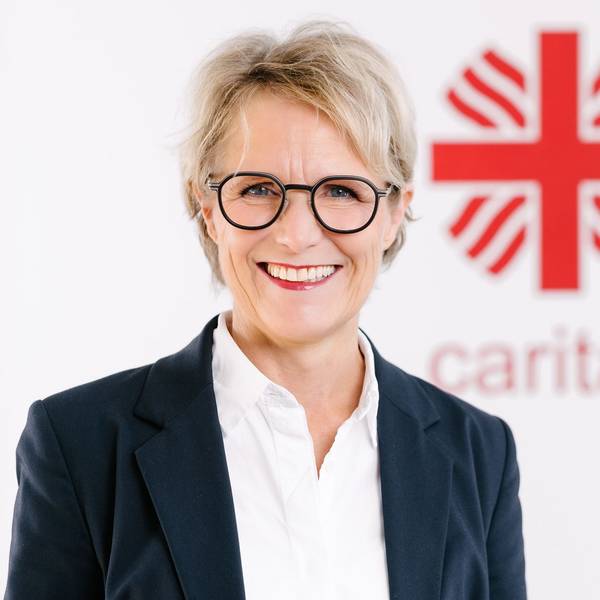 Das Foto zeigt die Finanzvorständin vor dem Caritas-Logo.