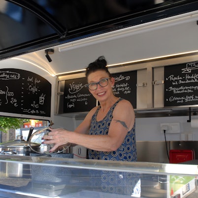 Eine Frau steht hinter einem Stand.