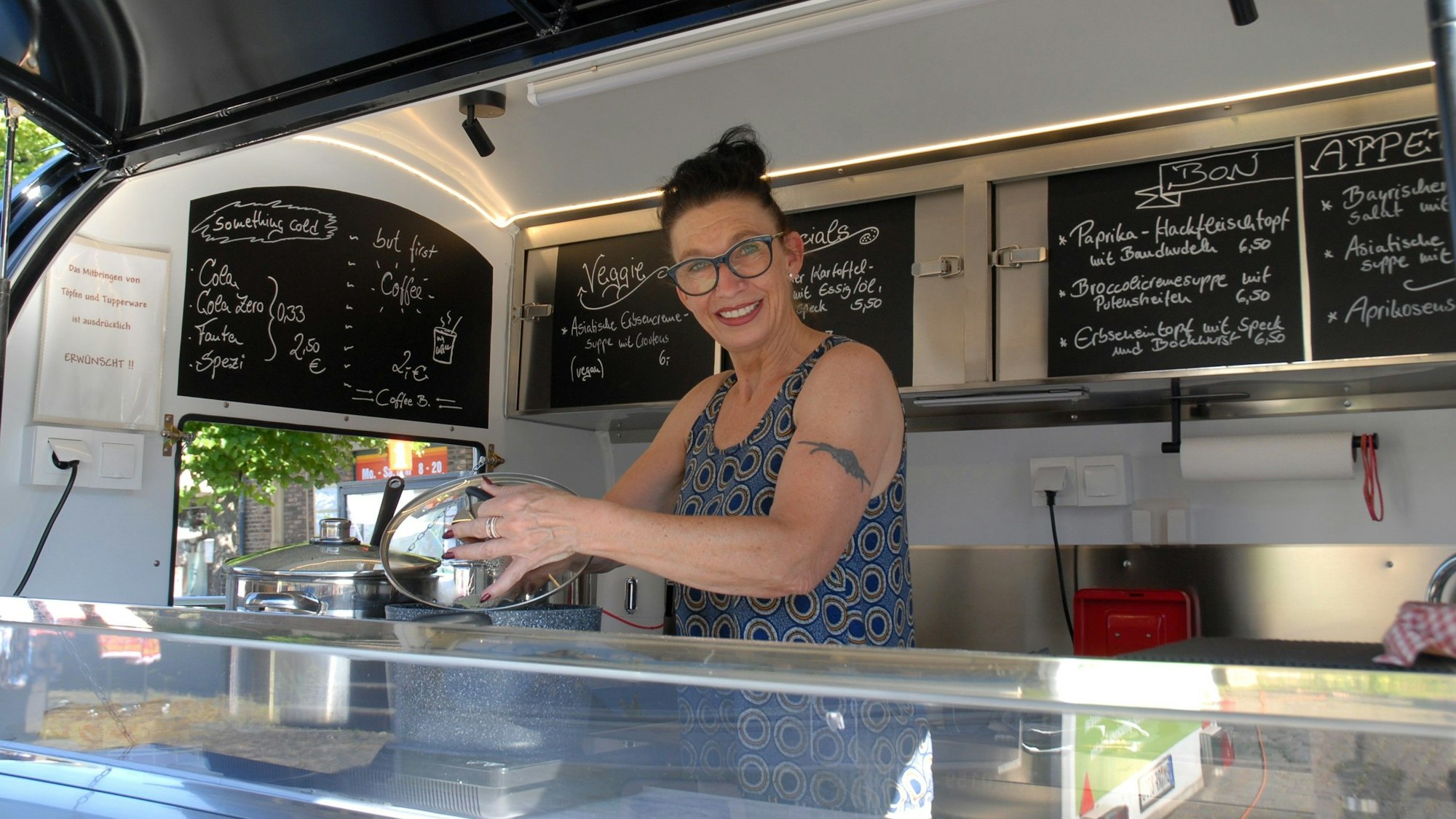 Eine Frau steht hinter einem Stand.
