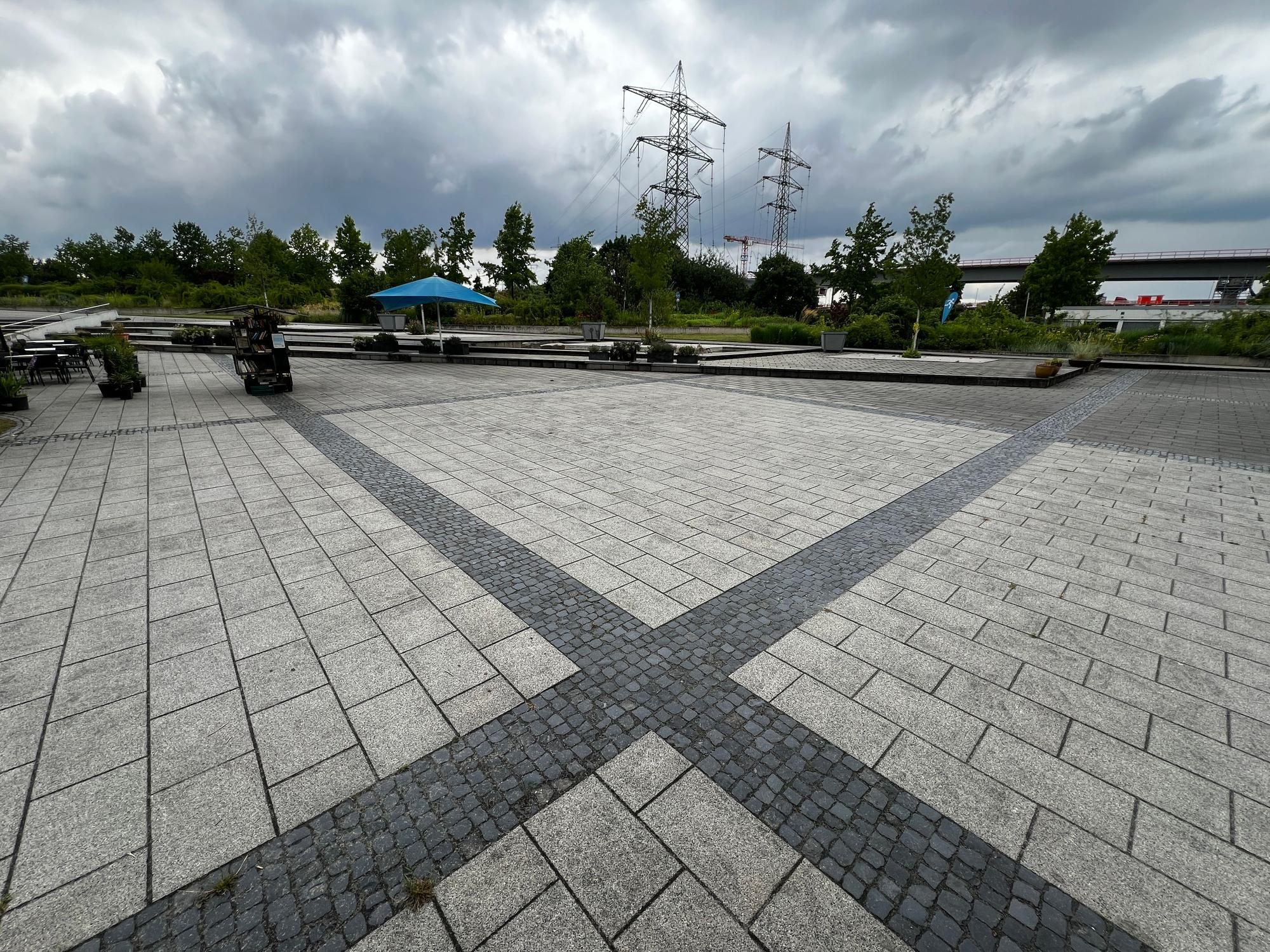 Eine große gepflasterte Flächze am Eingang des Neulandparks in Leverkusen