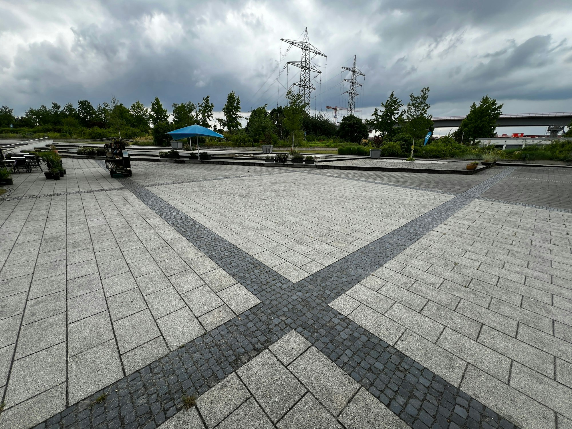 Eine große gepflasterte Flächze am Eingang des Neulandparks in Leverkusen