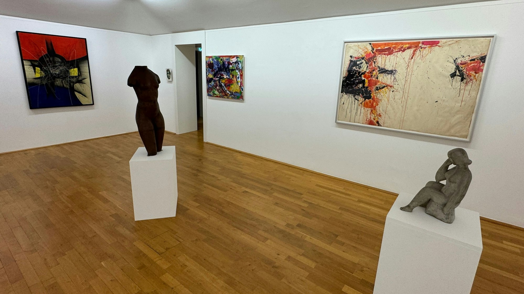 Kunstwerke stehen in einem Museumsraum.