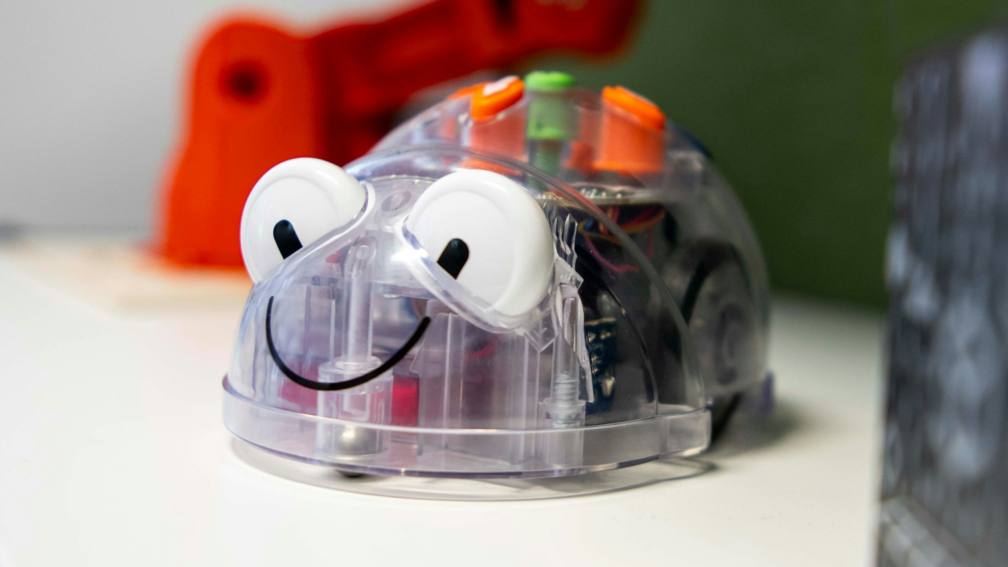 Das Bild zeigt einen kleinen Roboter, der mit wenigen Knopfdrücken programmiert werden kann. Er hat die Form einer Maus.