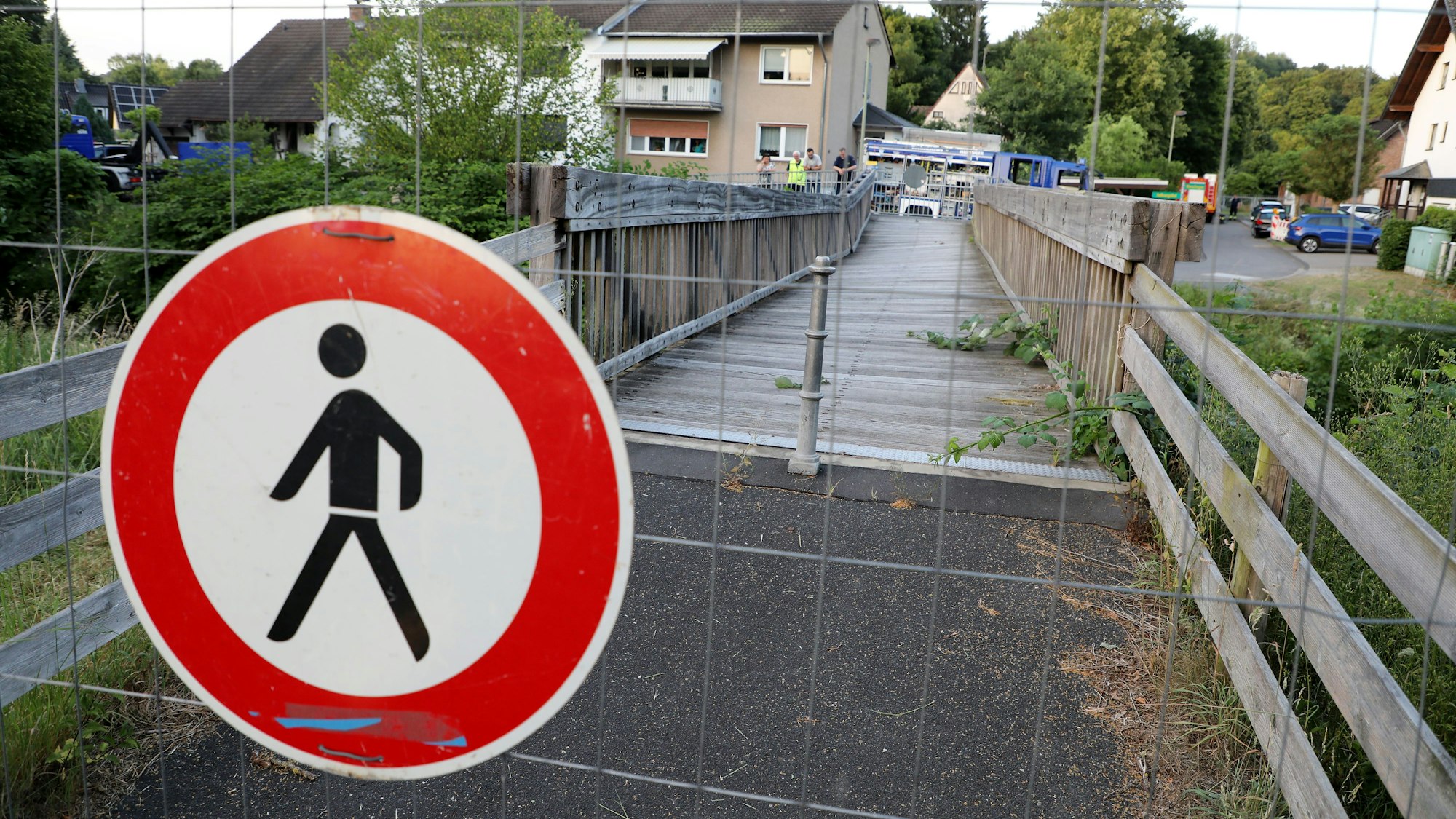 Eine Holzbrücke in Rösrath ist mit Gittern und einem Schild „Durchgang verboten“ gesperrt.
