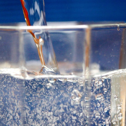 Sprudelwasser wird in ein Glas geschüttet.