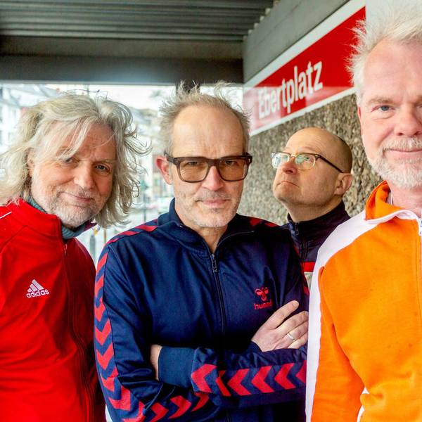 Die vier Mitglieder der Band Erdmöbel stehen in Trainingsanzügen an der Kölner Haltestelle Ebertplatz.