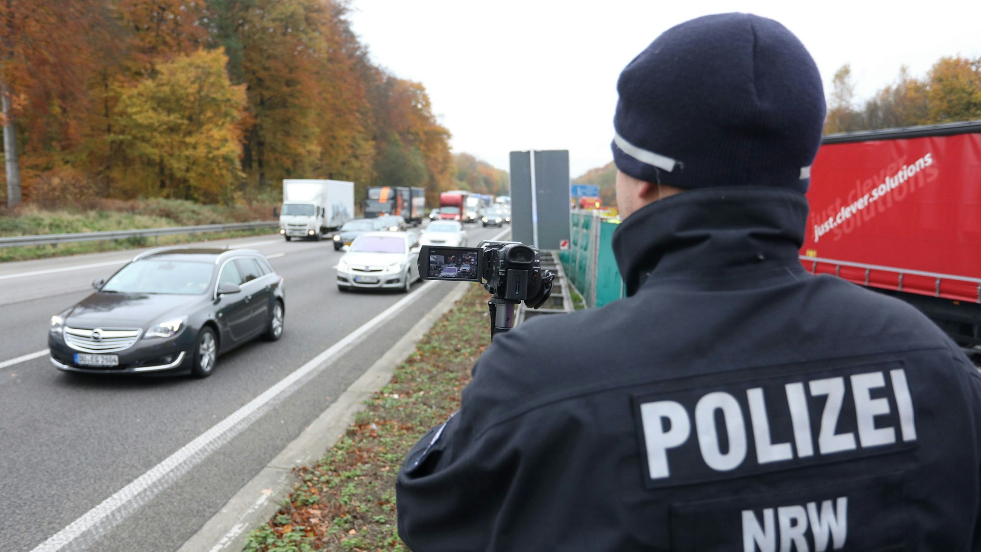 En Polizist filmt in Ratingen auf der A3 bei einem schweren Unfall auf der Gegenspur vorbeifahrende Autos, um eventuelle Gaffer zu identifizieren.