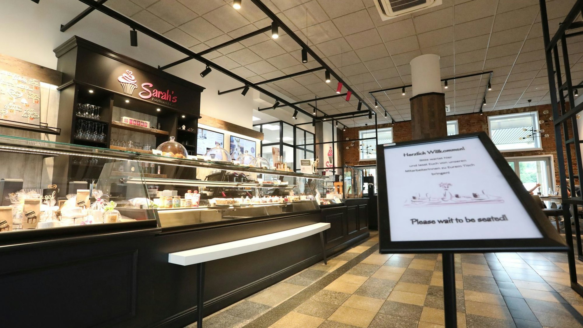 Ein in braun gehaltenes Café´ mit einer langen Kuchen- und Tortentheke.