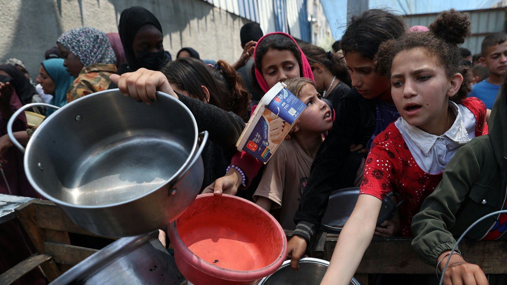 Kinder im Gazastreifen warten auf Essen an einem Verteilzentrum in Nuseirat.