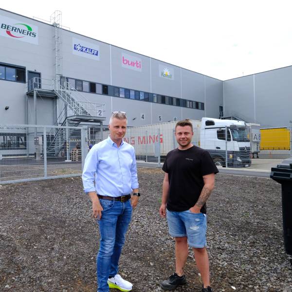 Daniel Claßen und Betriebsleiter Steffen Steinhauer stehen vor einer Logistikhalle in einem Gewerbegebiet.