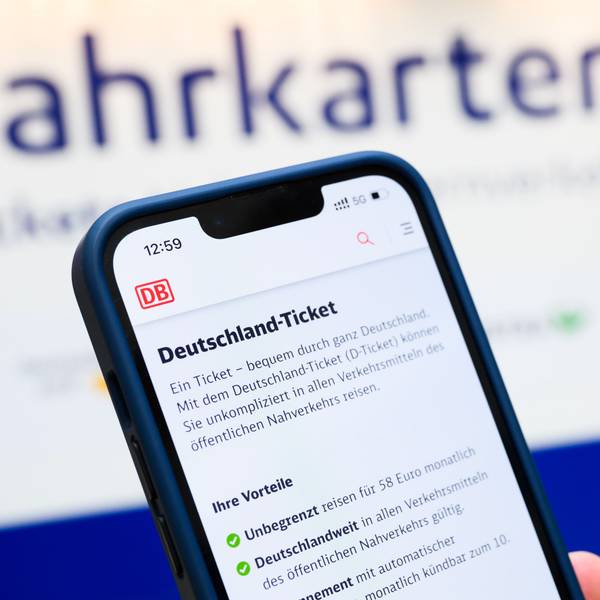 Eine Person hält am Hauptbahnhof ein Smartphone in der Hand, auf dessen Display eine Information zum Kauf des Deutschlandtickets zu sehen ist.