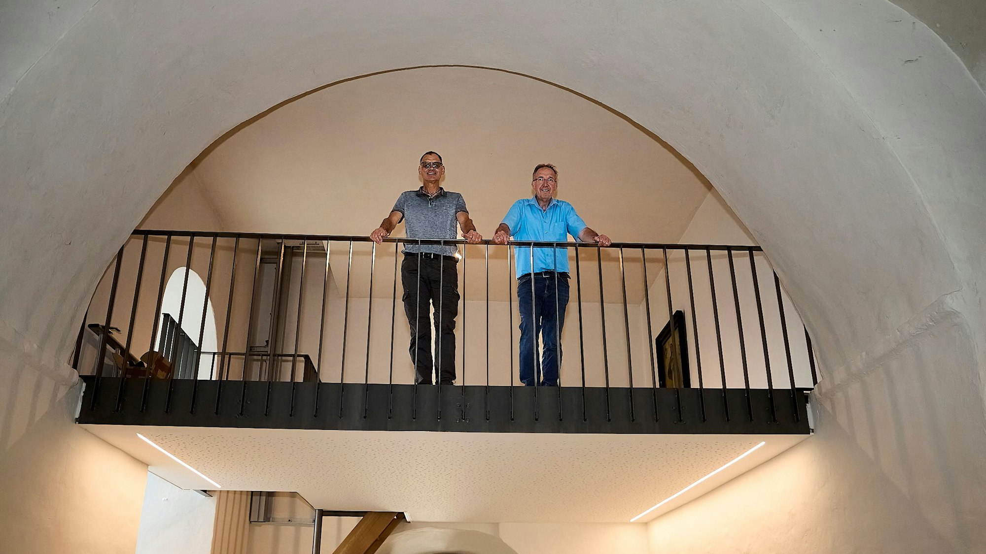 Herbert Faßbender (links) und Gregor Mauel stehen auf einer Empore in einer Kirche.