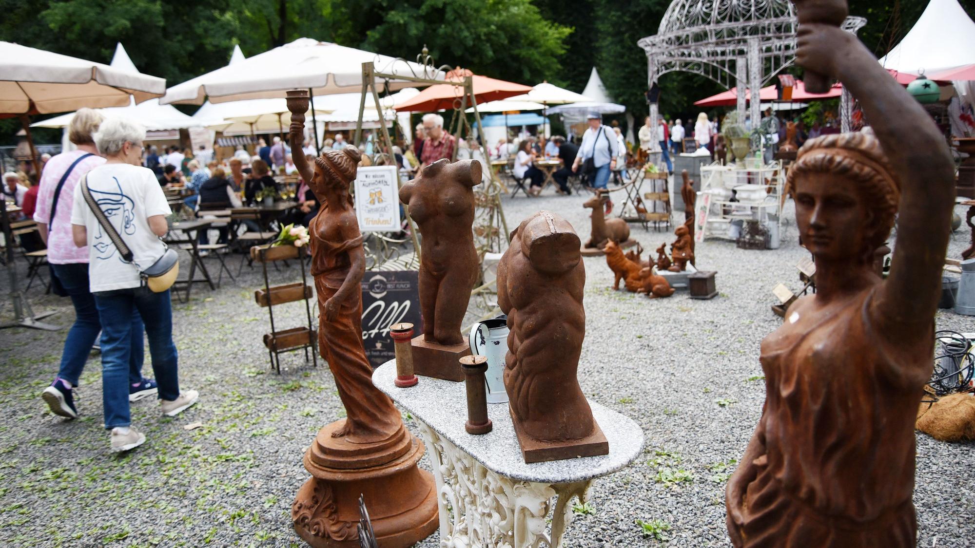 Zwei Frauen laufen an antikisierenden Statuen vorbei.