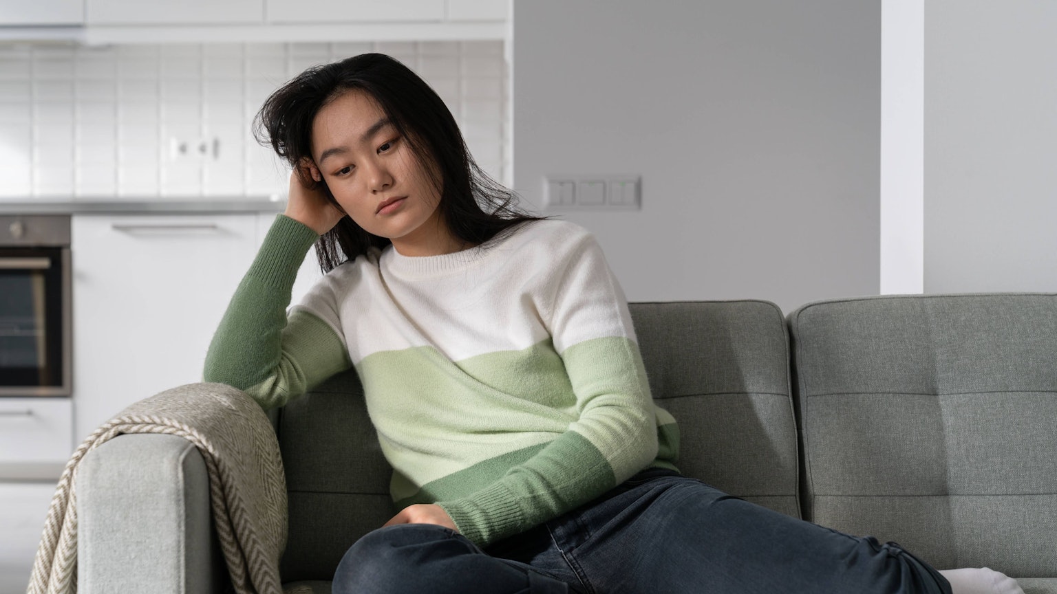 Traurige Frau sitzt auf dem Sofa