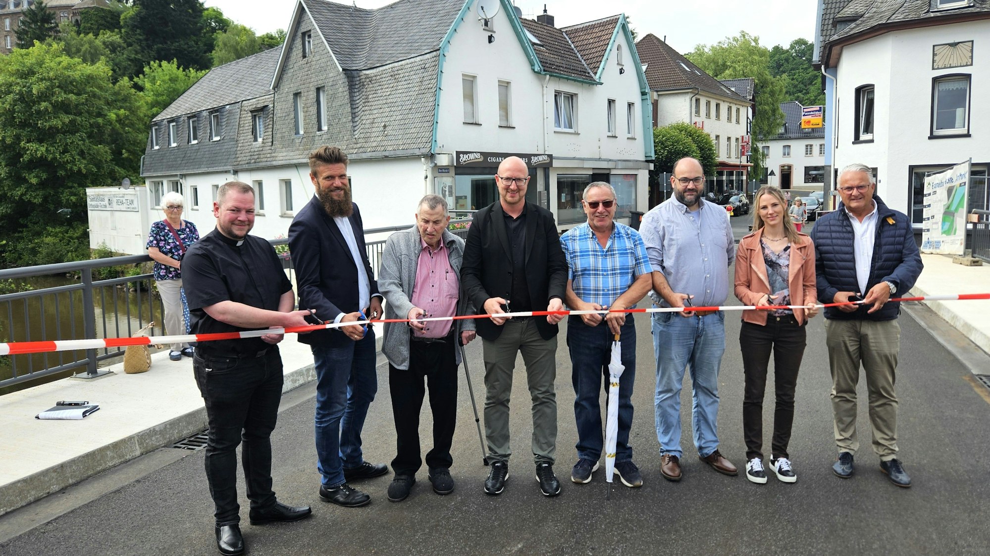 Acht Personen stehen auf der Brücke hinter einem Flatterband.