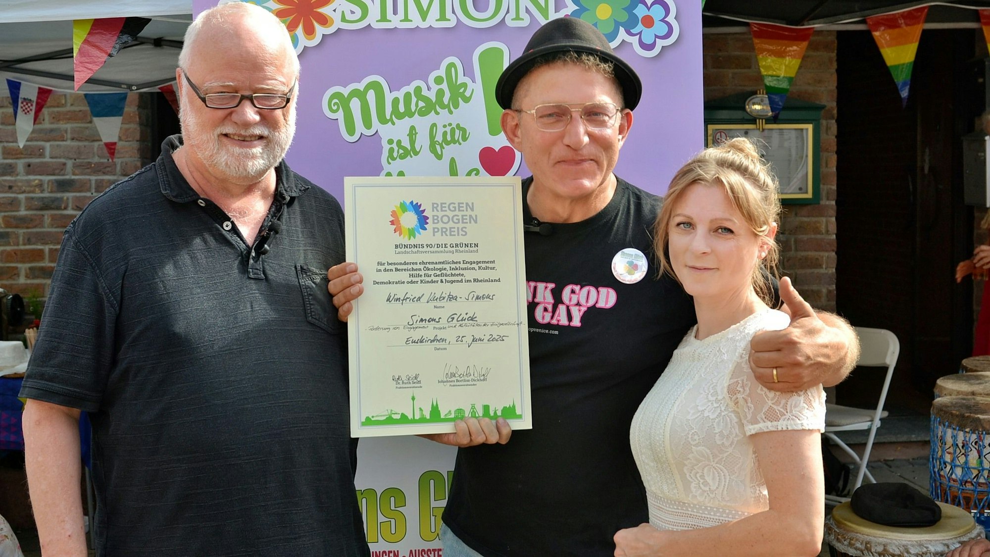 Winfried Kubitza-Simons (Mitte) zeigt eine Urkunde, Johannes Bortlisz-Dickhoff und Myriam Kemp stehen an seiner Seite.