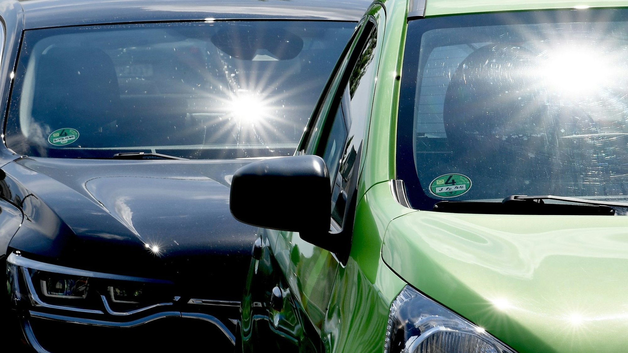 Autos stehen in praller Sonne nebeneinander.