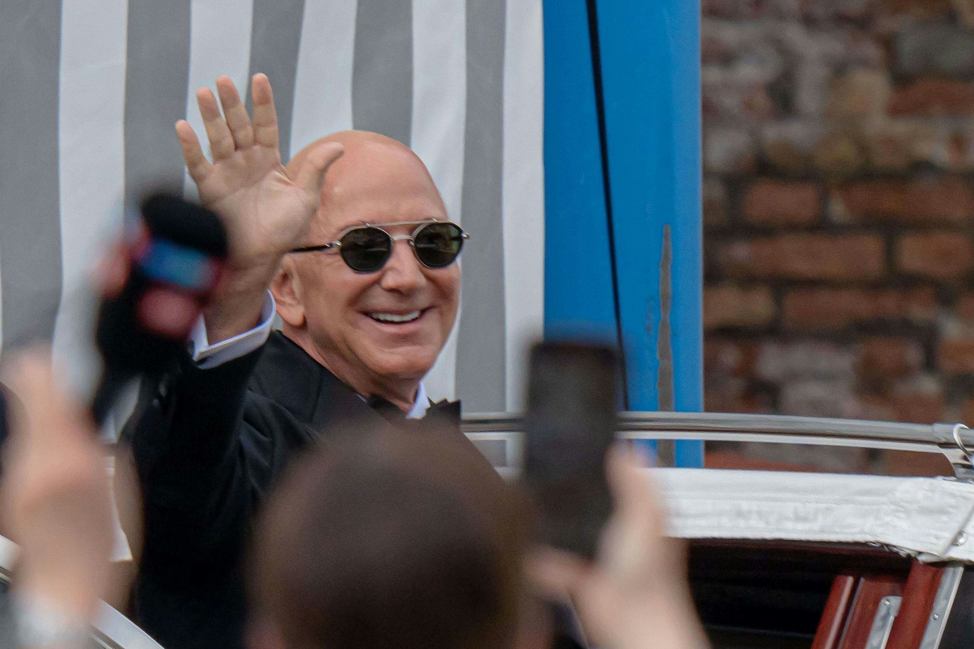 Jezz Bezos winkt den Fotografen zumindest zu.
