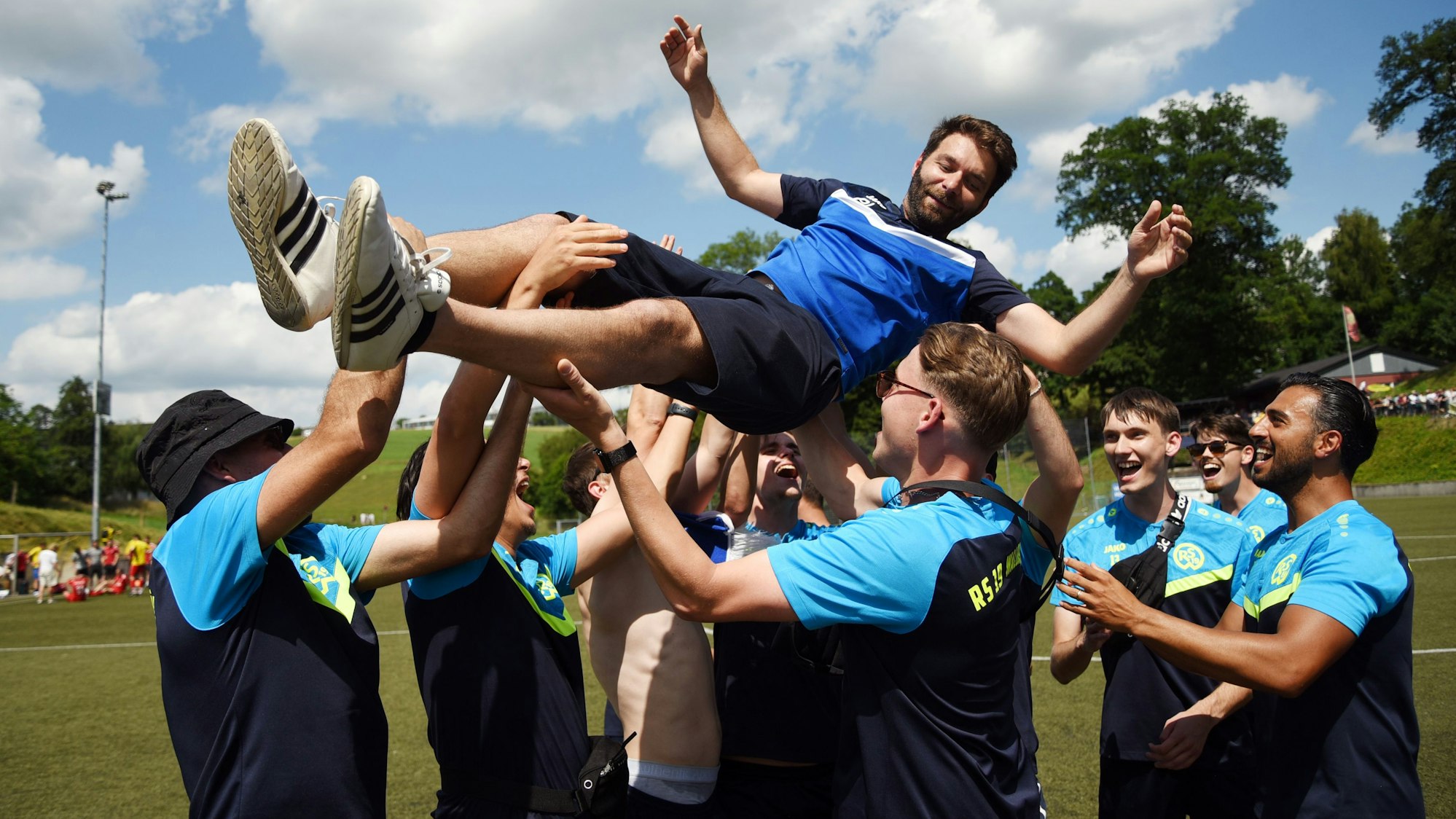 Eine Fußballmannschaft wirft einen Mann in die Luft.