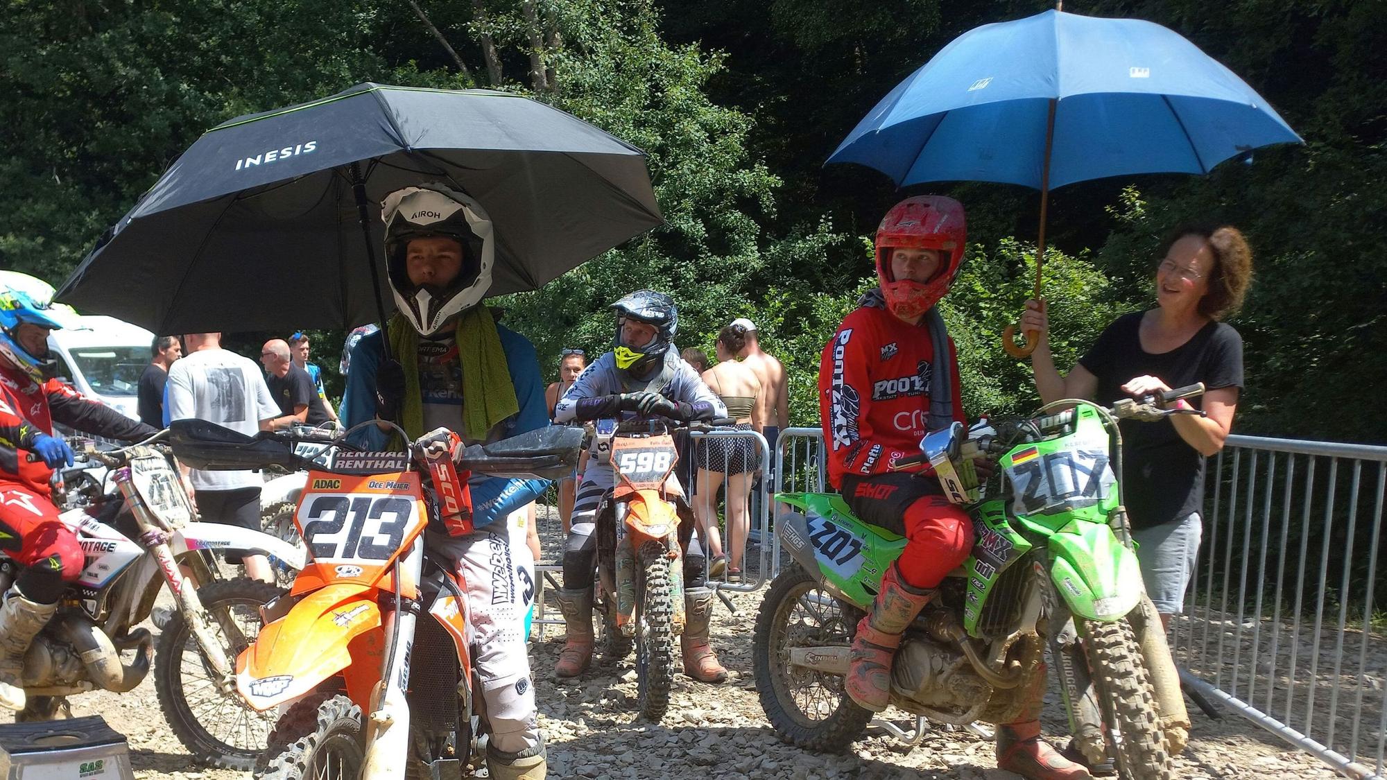 Beim ADAC MX-Cup in Bielstein lassen sich die Fahrer vor dem Start von Sonnenschirmen schützen.