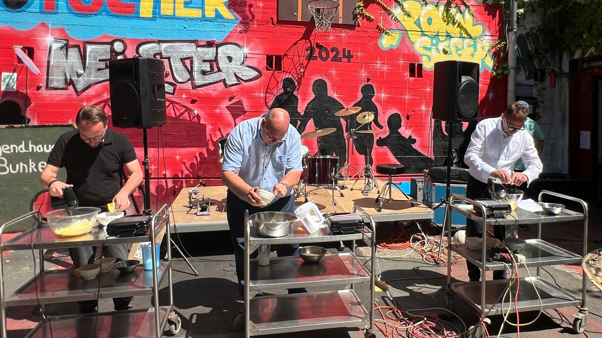 Drei Männer backen Waffeln.