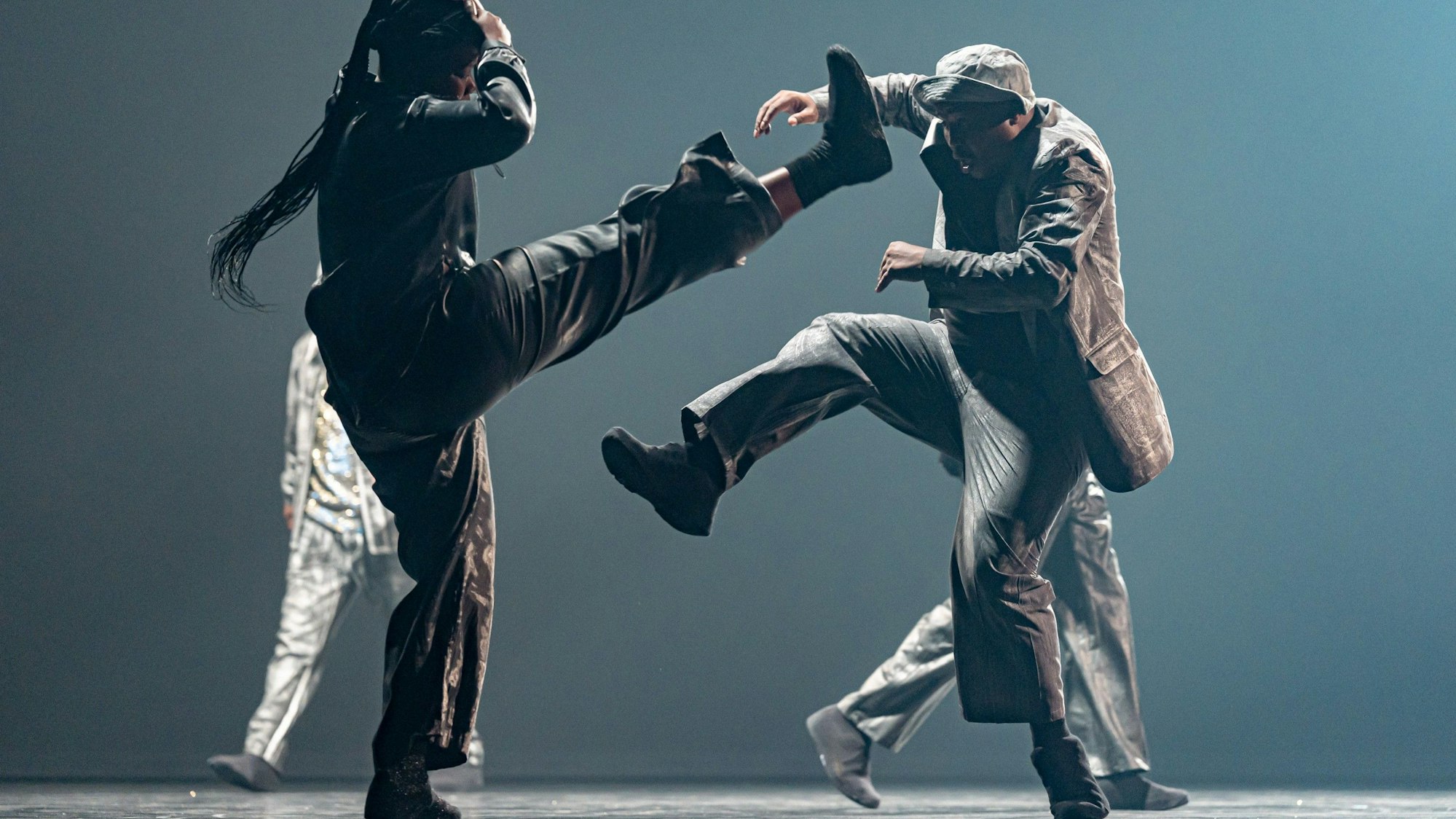 Die südafrikanischen Tänzerinnen und Tänzern von Impilo Mapantsula werfen die Beine hoch.