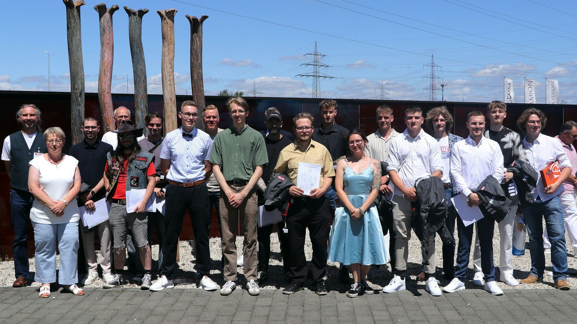 Auf em Bild ist eine Gruppe junger Leute zu sehen, die ihre Gesellenzeugnisse erhalten haben.