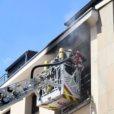 Das Foto zeigt Feuerwehrleute, die von dem Korb der Drehleiter aus das Feuer löschen.