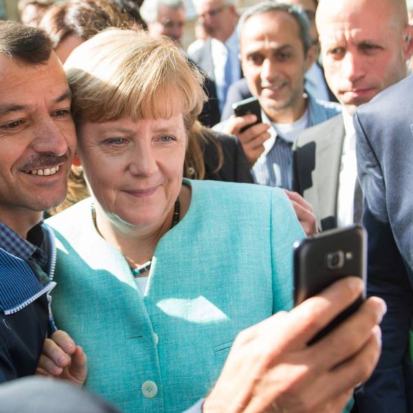 ARCHIV - 10.09.2015, Berlin: Bundeskanzlerin Angela Merkel (CDU) lässt sich nach dem Besuch einer Erstaufnahmeeinrichtung für Asylbewerber der Arbeiterwohlfahrt (AWO) und der Außenstelle des Bundesamtes für Migration und Flüchtlinge in Berlin-Spandau für ein Selfie zusammen mit einem Flüchtling fotografieren. (zu dpa: «Merkel mit Geflüchteten am Tisch - zehn Jahre nach 2015») Foto: Bernd von Jutrczenka/dpa +++ dpa-Bildfunk +++
