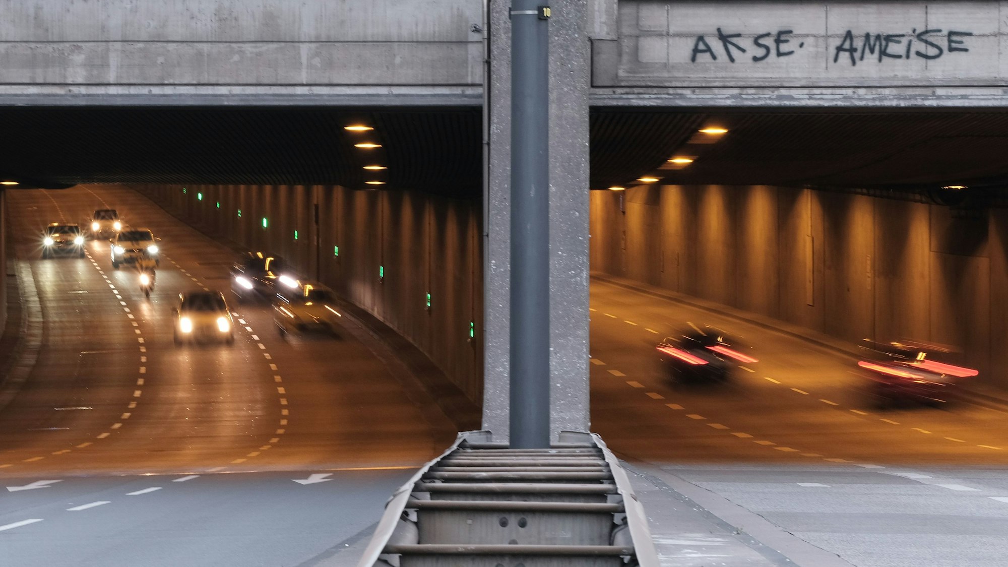 Autos fahren in einen Straßentunnel hinein und hinaus.