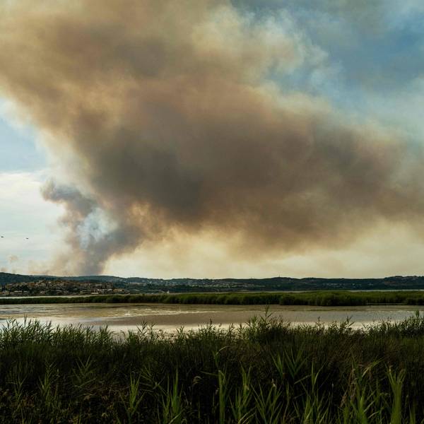 29.06.2025, Frankreich, Bizanet: Dieses Foto zeigt zwei Löschflugzeuge, die westlich der Stadt Narbonne im Südwesten Frankreichs, in der Nähe einer Rauchfahne, verursacht durch einen Waldbrand, an einem Berghang fliegen. Ein Teil des Corbières-Gebirges steht in Flammen, so dass die Abtei Fontfroide und ein Campingplatz vorsorglich evakuiert werden mussten, wie die Präfektur und die Feuerwehr des Departements mitteilten. Foto: Idriss Bigou-Gilles/AFP/dpa +++ dpa-Bildfunk +++