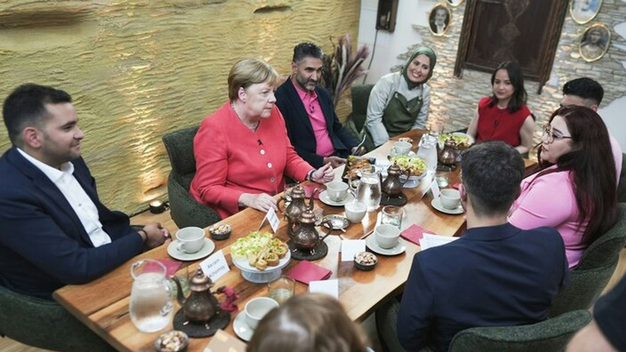 Angela Merkel hat sich in einem syrischen Restaurant in Berlin mit fünf Geflüchteten getroffen, deren Leben sie mit ihrer Politik vor zehn Jahren maßgeblich beeinflusst hat. (Bild: WDR/Mirko Polo)