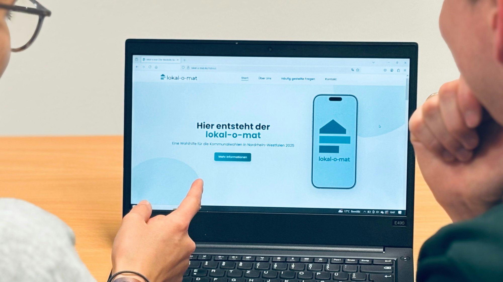 Zwei Menschen blicken auf einen Computer-Bildschirm.