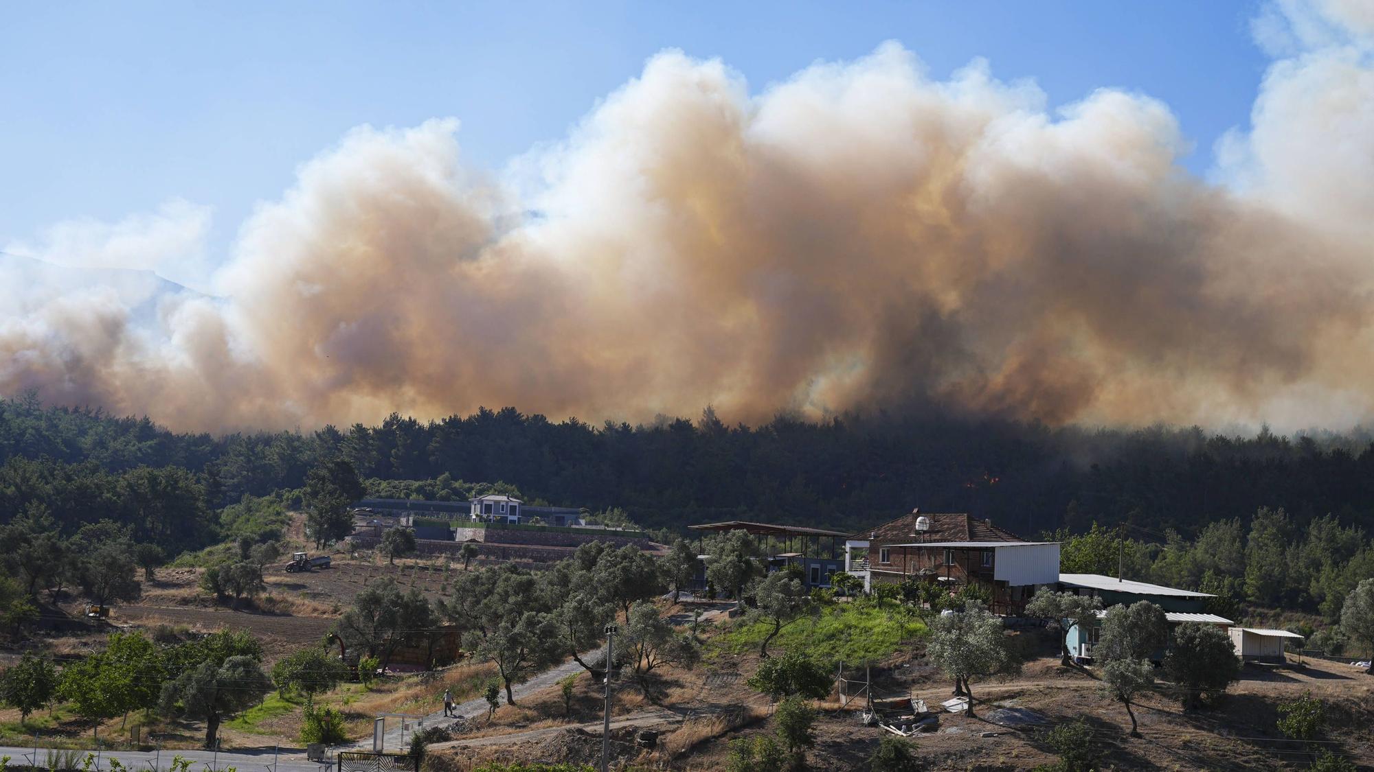 Löscharbeiten in Izmir: Feuerwehrkräfte kämpfen am Boden und aus der Luft gegen massive Waldbrände im Bezirk Menderes – dichter Rauch erschwert den Einsatz.