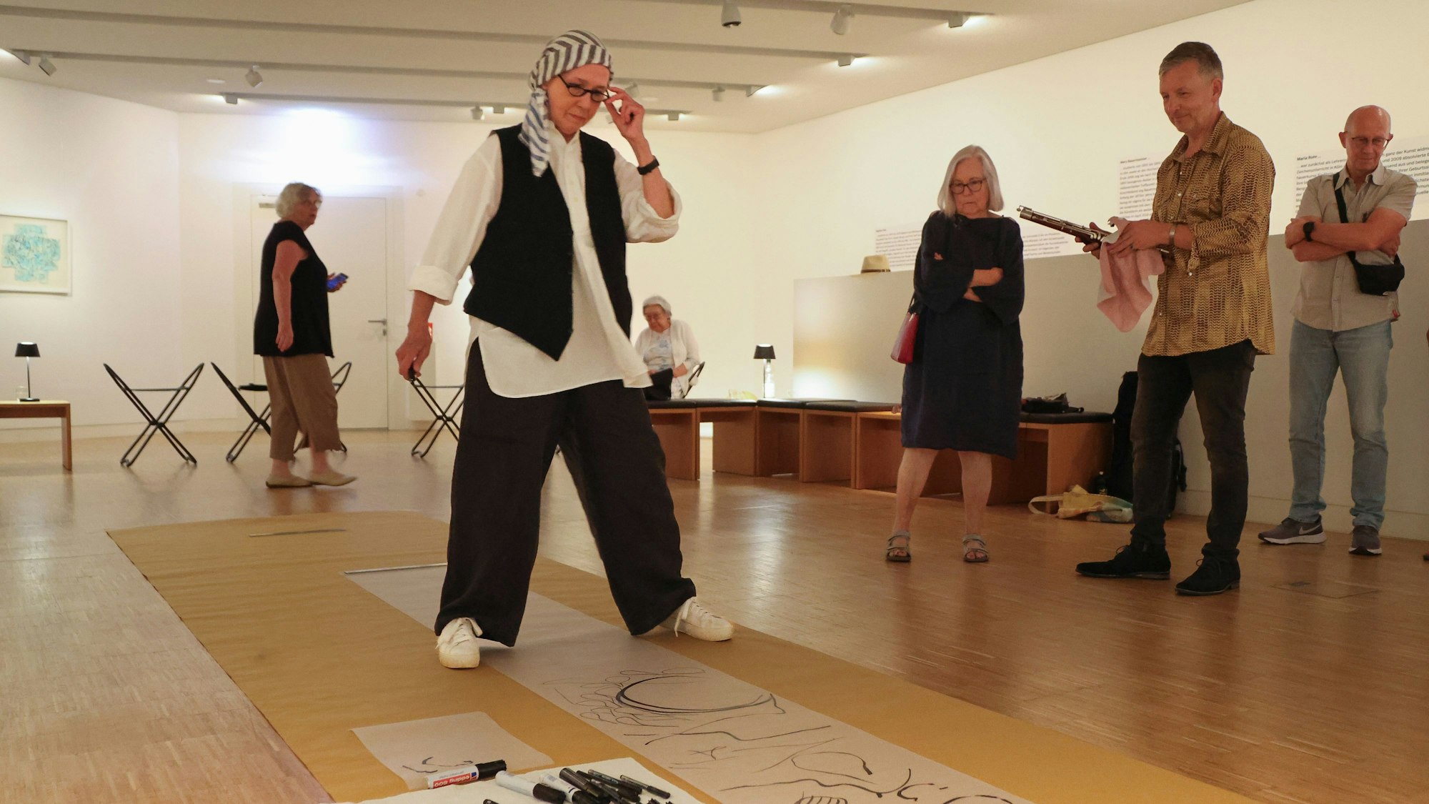 Mit zahlreichen schwarzen Stiften erstellte Daphna Koll (vorne)  live eine weitere grafische Partitur.