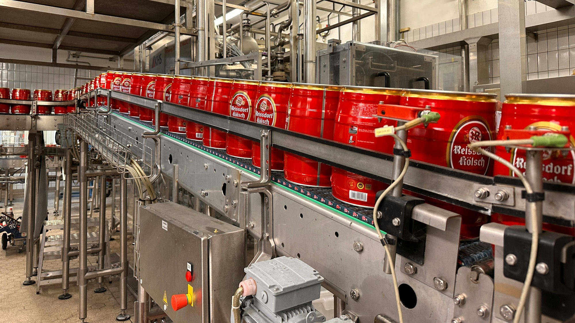 Ein Mann steht in einem Foyer neben dem Firmenschild Kölner Brautradition Seit 1894.