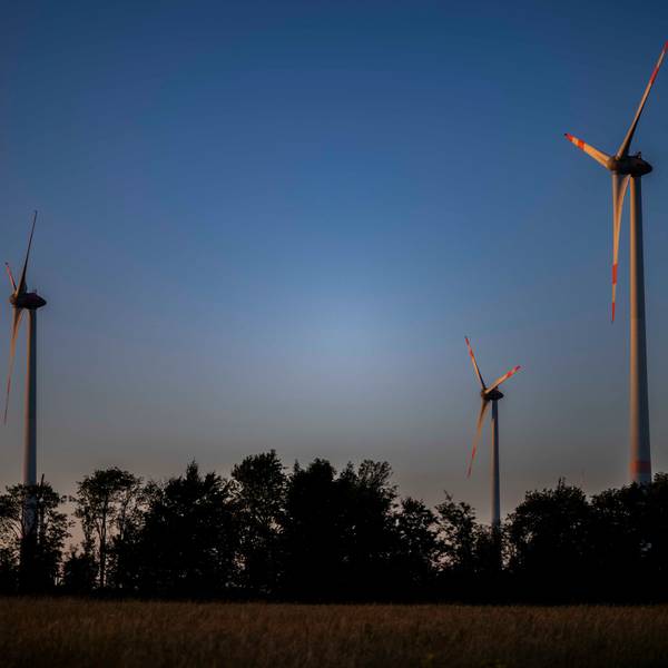 Das Bild zeigt einen Teil des Windparks in Schleiden im Sonnenuntergang.
