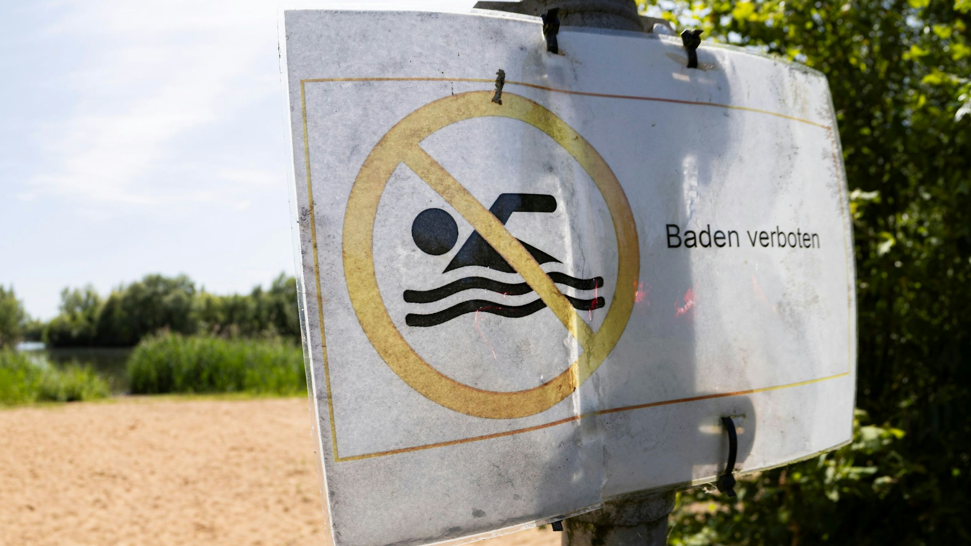 Ein «Baden verboten»- Schild an einem See.