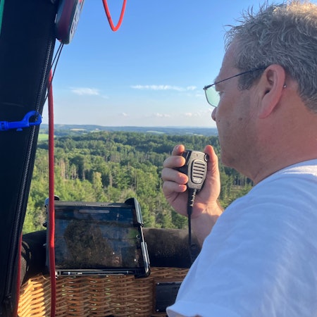 Ein Pilot eines Heißliftballons spricht in ein Funkgerät.