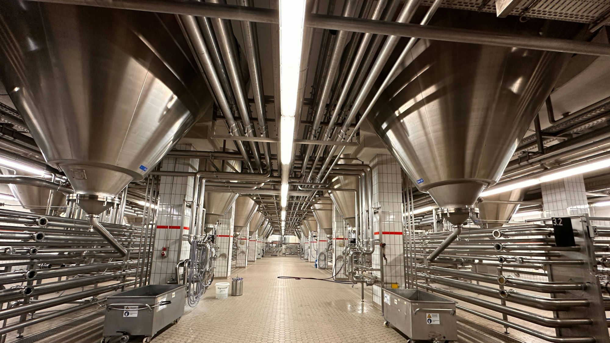 Blick in eine große Halle mit stählernen Rohren und großen Tanks