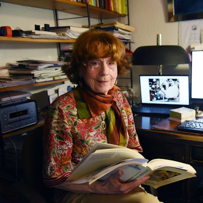 Das Foto zeigt Barbara Stewen, im Hintergrund ein Computermonitor mit einem Foto von Olga Oppenheimer.