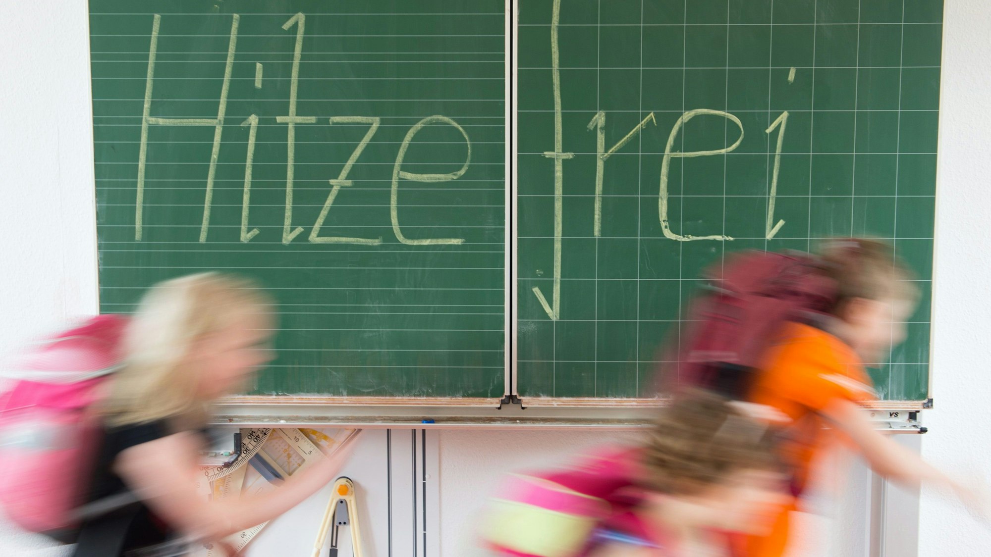 ARCHIV - 30.06.2015, Sachsen, Dresden: ILLUSTRATION - Schüler einer 2. Klasse laufen in einer Grundschule an einer Tafel mit der Aufschrift "Hitzefrei" vorbei.
Hitzefrei - das wünschen sich wohl fast alle Schüler, wenn es heiß wird. Foto: Sebastian Kahnert/dpa-Zentralbild/dpa - ACHTUNG: Dieses Foto hat dpa bereits im Bildfunk gesendet - Honorarfrei nur für Bezieher des Dienstes dpa-Nachrichten für Kinder +++ dpa-Nachrichten für Kinder +++ | Verwendung weltweit
