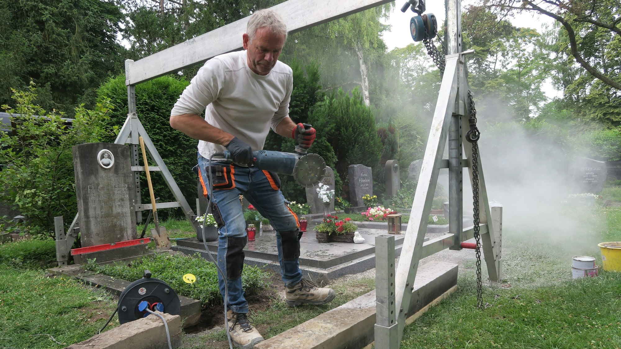 Markus Schürmeyer von „Kliewe & Janke“ bei der Arbeit an der Einfassung des Grabes.