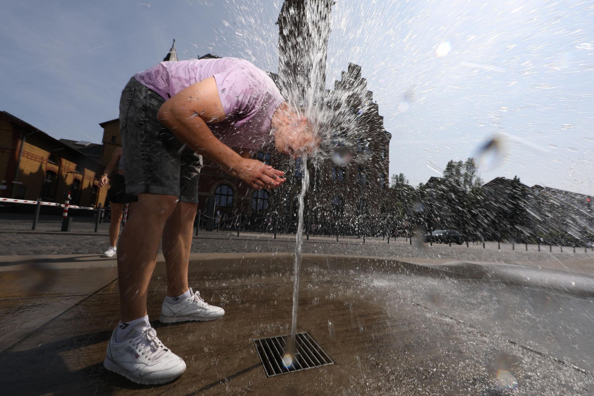 13.06.2025, Köln: Eine kleine Abkühlung für Edgar und Gulia am Brunnen am Hafenamt. Wetter, Feature: Köln erlebt den ersten Hitzetag des Jahres mit Temperaturen von mehr als 30°C. Foto: Arton Krasniqi