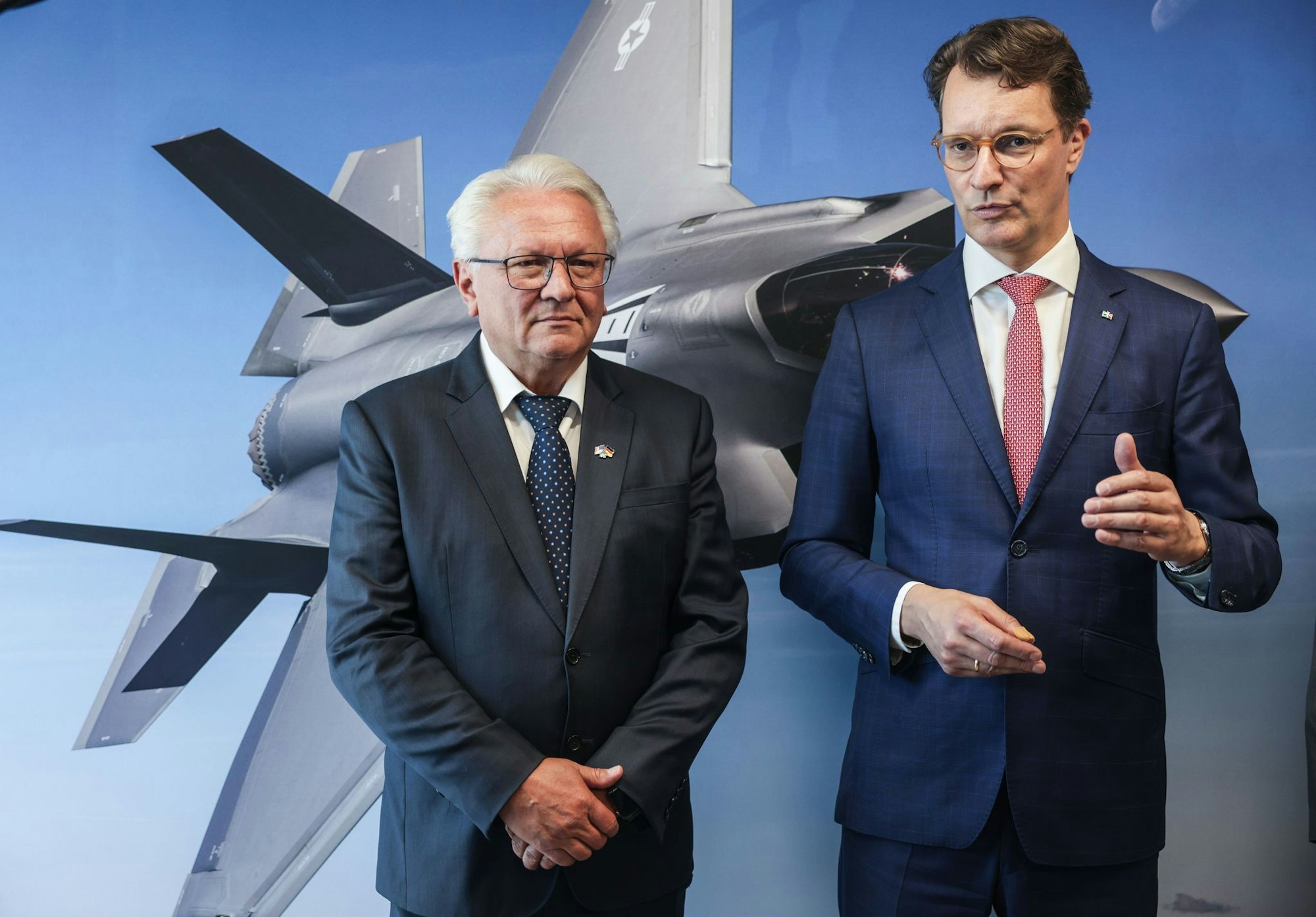 Papperger und Wüst vor einem Bild des F-35-Flugzeugs. Ende nächsten Jahres soll das erste Rumpfmittelteil dieses Tarnkappenbombers in Weeze fertig sein.