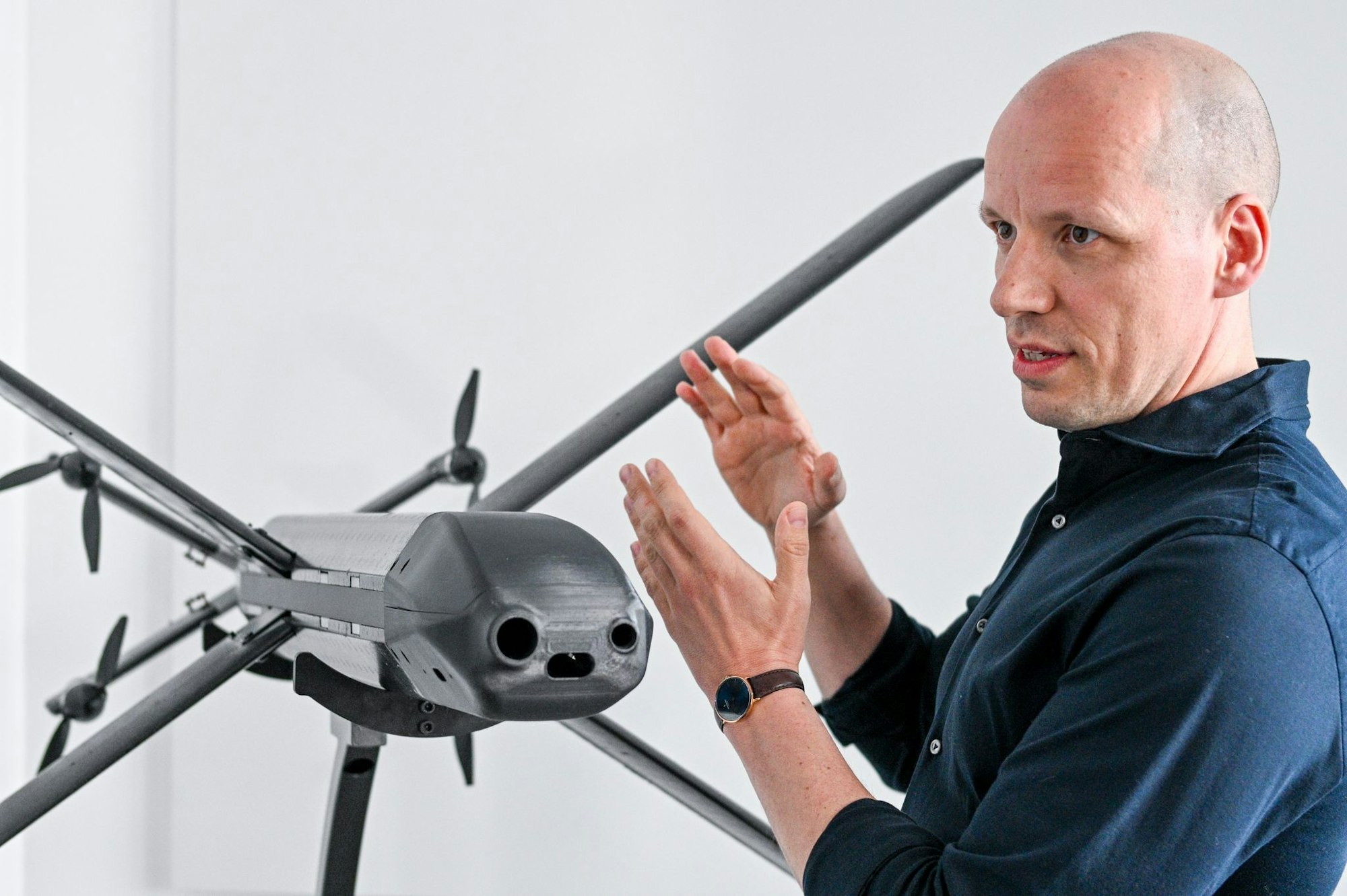 Ein Modell der HX-2-Drohne von Helsing, daneben der Mitgründer und Co-Firmenchef Gundbert Scherf.