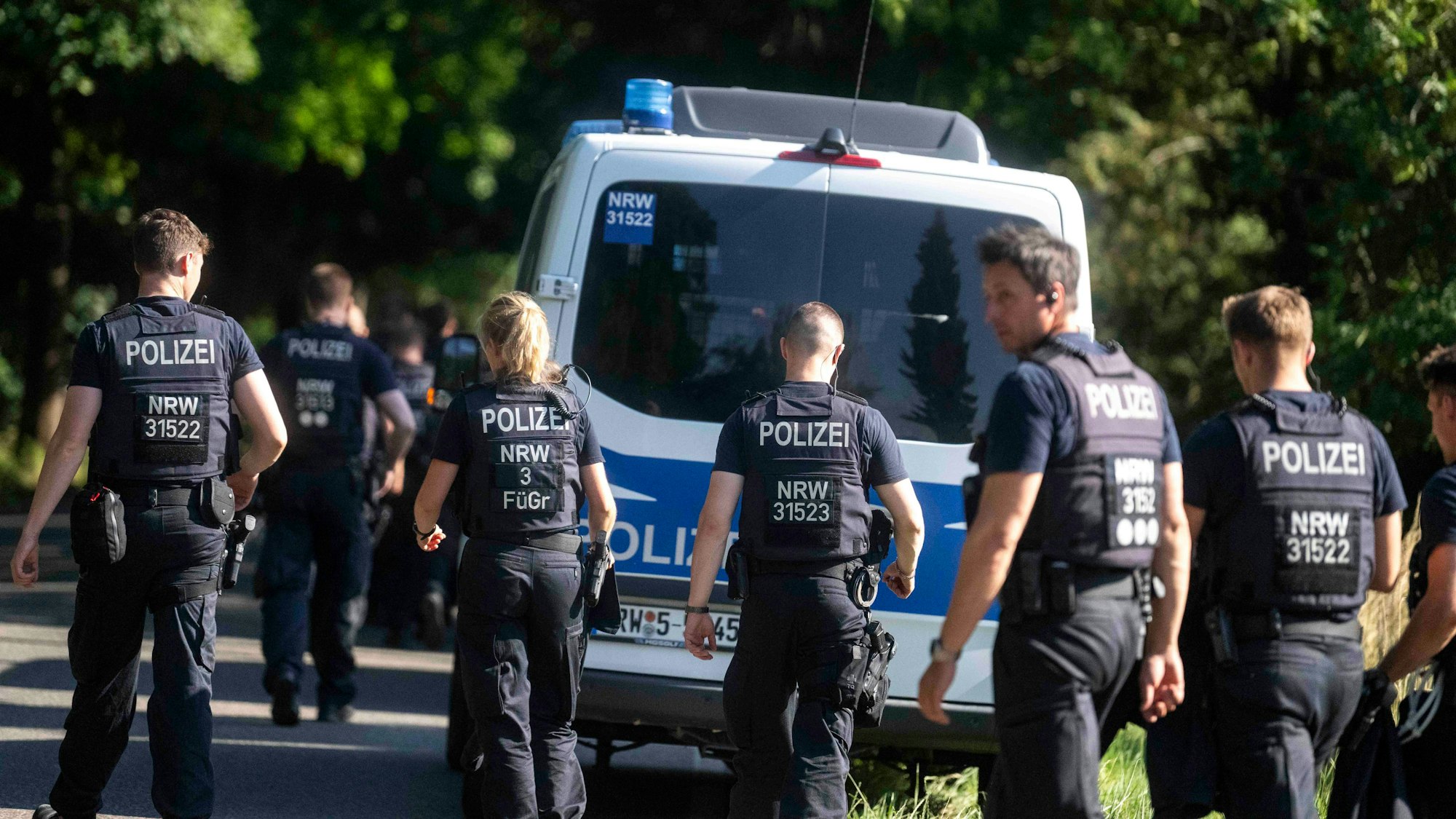 Das Bild zeigt Polizeibeamte auf dem Weg zu ihren Fahrzeugen.