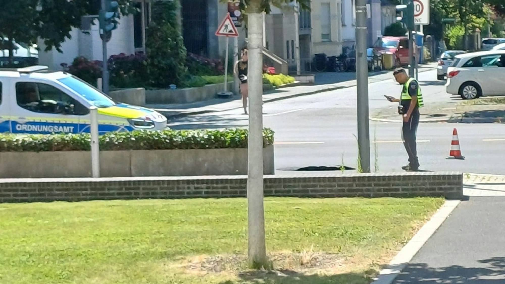 Ein Mitarbeiter vom Ordnungsamt der Stadt Bonn nimmt das Loch in der Adenauerallee erstmals in Augenschein.
