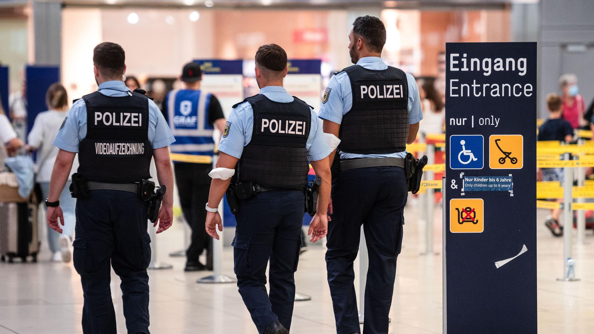 Beamte der Bundespolizei gehen an den Sicherheitskontrollen des Flughafens Köln/Bonn vorbei. (Archivbild)